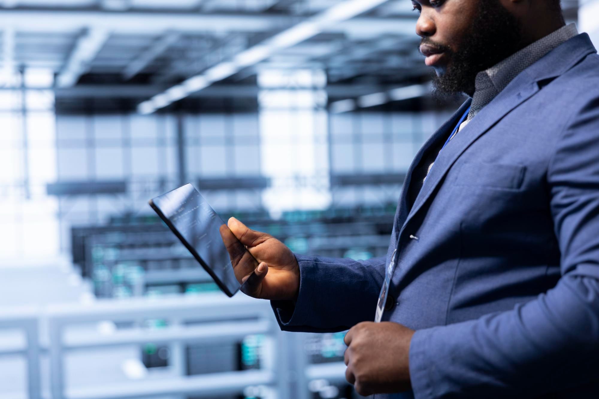 An engineer holding a tablet in a bright data centre